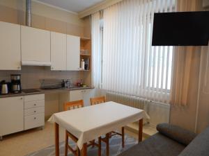 eine kleine Küche mit einem weißen Tisch und Stühlen in der Unterkunft Immalanjärvi in Imatra