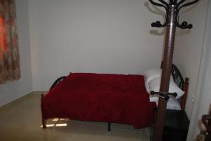 a bedroom with a bed with a red blanket at Apartamentos Bchraya in Laayoune
