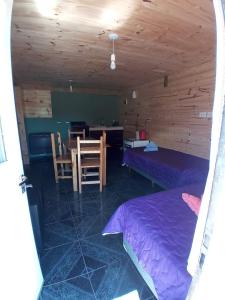 Pokój z łóżkiem, stołem i krzesłami w obiekcie Cabaña El Guardian Del Bosque w mieście El Hoyo