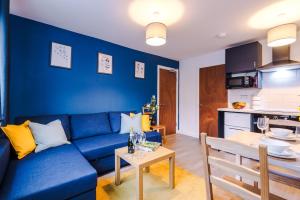 a blue living room with a blue couch and a table at NEW! Spacious 2-bed Apartment in Crewe by 53 Degrees Property, ideal for Business & Professionals, FREE Parking - Sleeps 6 in Crewe