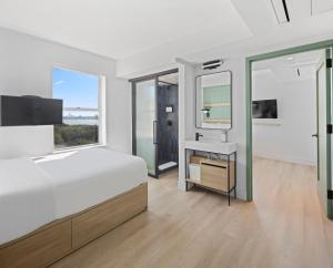 een slaapkamer met een bed, een wastafel en een spiegel bij Riverside Tower Hotel in New York