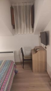 um quarto com uma cama e uma secretária com uma televisão em Hostal Bavieca em Medinaceli