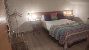 um pequeno quarto com uma cama e 2 candeeiros em Hostal Bavieca em Medinaceli