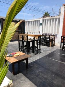 un grupo de mesas y sillas de madera en un patio en Pointbreak Surf Camp, en Huanchaco