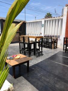 a group of wooden tables and chairs on a patio at Pointbreak Surf Camp in Huanchaco