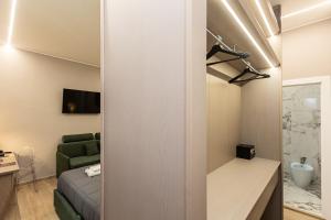 Habitación pequeña con sofá verde y cama en IRON Luxury Rooms, en Roma 79 fotos más