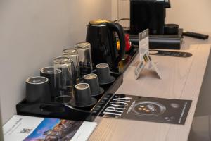 Un mostrador con una cafetera y tazas. en IRON Luxury Rooms, en Roma