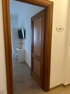 una puerta de madera abierta en una habitación con TV en Panoramic Rooms Salerno Affittacamere, en Salerno