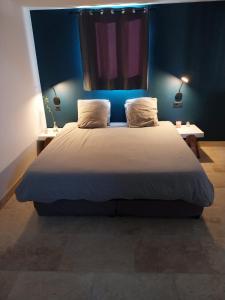 a bedroom with a large bed with blue walls at Chalet détente proche plage in La Ciotat