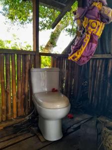 a toilet sitting on a porch with a wooden fence at Castle Tree House And Bungalow in White Sands
