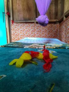 a group of three toy animals laying on a bed at Castle Tree House And Bungalow in White Sands