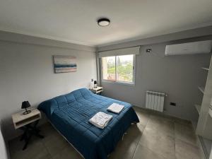Un dormitorio con una cama azul y una ventana en Departamento Pueyrredon en Salta