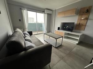 sala de estar con sofá y TV en Departamento Pueyrredon en Salta