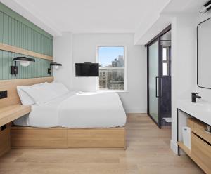 um quarto com uma cama, uma janela e um lavatório em Riverside Tower Hotel em Nova Iorque