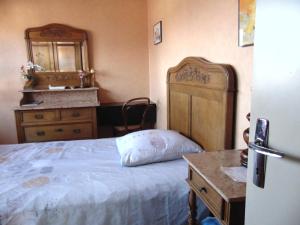 Schlafzimmer mit einem Bett, einer Kommode und einem Spiegel in der Unterkunft Maison dans un cadre de verdure in Saverne