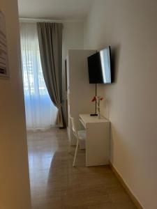 a room with a desk and a tv on a wall at Panoramic Rooms Salerno Affittacamere in Salerno