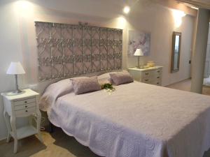 a bedroom with a large white bed with two night stands at B&B Il Cotogno in Gavi