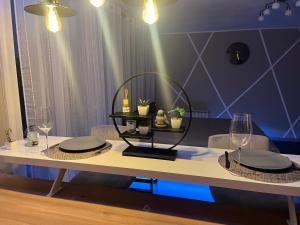 een eettafel met borden en glazen erop bij Love Room & Spa Jacuzzi in Fleury-les-Aubrais