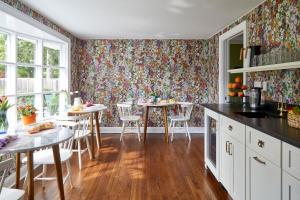 Kent的住宿－The Kent Collection，厨房配有花卉图案的壁纸和桌椅