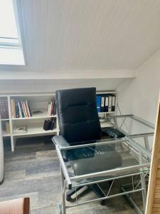 - un bureau en verre avec une chaise noire dans l'établissement Maison vue SEMNOZ, à Annecy