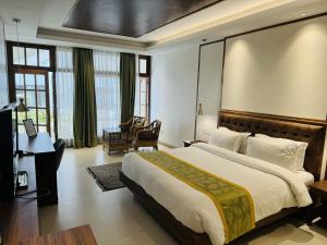 Habitación de hotel con cama grande y escritorio. en Noblestride Resort en Gangtok