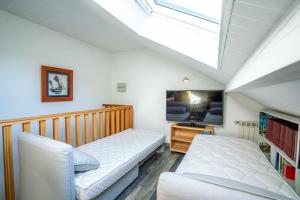 - une chambre mansardée avec un lit et une lucarne dans l'établissement Maison vue SEMNOZ, à Annecy