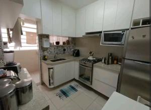 a kitchen with white cabinets and a stainless steel refrigerator at Aconchego 1 in São Roque