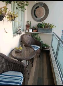 balcón con mesa, sillas y plantas en Aconchego, en São Roque