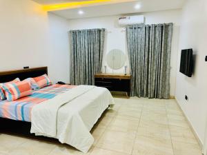 a bedroom with a bed and a mirror at Luxury Villa within Abuja Sanctuary in Abuja