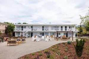 a large white building with chairs and tables at Kettle Valley Beach Resort in Penticton
