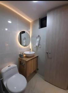a bathroom with a toilet and a sink and a mirror at Se alquila apartamento in Cali
