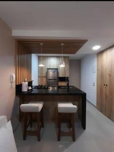 a kitchen with a large island with two stools and a stove at Se alquila apartamento in Cali