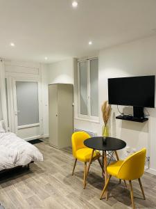 um quarto com uma cama, uma mesa e cadeiras em Studio cosy 