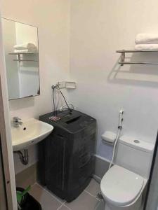 a white bathroom with a toilet and a sink at LD Cozy 1BR Grace Residences, Taguig near BGC in Manila