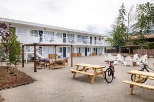 a building with picnic tables and chairs in front of it at Kettle Valley Beach Resort in Penticton