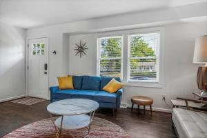 uma sala de estar com um sofá azul e uma mesa em ELYSIUM - Whole House - 4BR 2BA - Hot Tub - Game Room - Fenced Yard - Pet Friendly em Grand Rapids