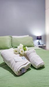 a pile of towels and flowers on a bed at Essencial Hotel & Spa in Mendoza