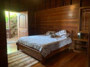 a bedroom with a bed and a wooden wall at ECO House with Sea View in Bastimentos