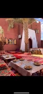 una mesa con platos y vasos encima en Dar El Hakim, le petit hôtel de Timimoun, en Timimoun
