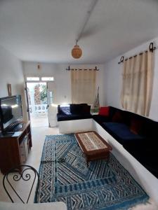 a living room with a couch and a tv at Menzel Churasco Djerba in Aghīr