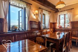 a dining room with wooden tables and windows at Hájenka Knížecí Pláně in Borová Lada