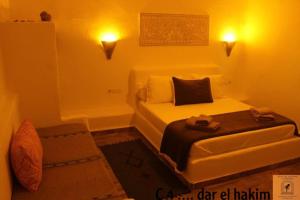 Habitación pequeña con cama y sofá en Dar El Hakim, le petit hôtel de Timimoun, en Timimoun