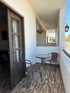eine Terrasse mit einem Tisch, Stühlen und einem Fenster in der Unterkunft Chulavista Loreto in Loreto
