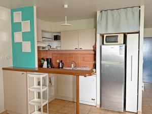 a small kitchen with a sink and a refrigerator at Duplex T2, 4 adultes, piscine, plage à proximité in Le Gosier +13 photos