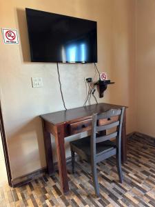 een bureau met een stoel en een televisie aan de muur bij Chulavista Loreto in Loreto