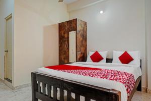 a bedroom with a large bed with red pillows at Oyo Flagship Sri Chowdeshwari Boarding And Lodging in Bangalore
