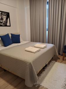 a bedroom with a bed with two towels on it at Usina Studio FMA-Coliving in Salta