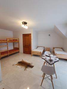 a room with two beds and a table and chairs at Willa Gorce in Ostrowsko