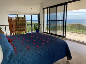 Un dormitorio con una cama azul con rosas rojas. en VILLA SIEMPRE DOMINGO, en Tecuán