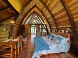 a bedroom with a bed and a wooden ceiling at Sacha Urco Lodge y Bosque Protector in Mindo